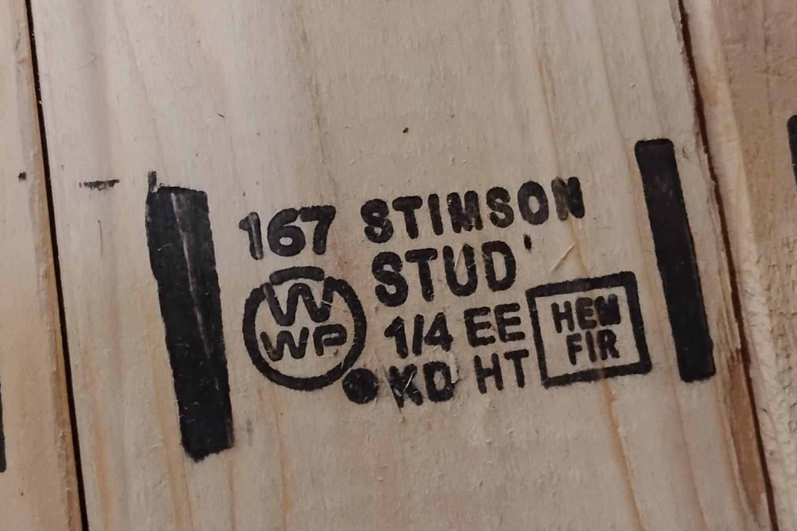 Close-up of a lumber grade stamp reading 167 Stimson, WWPA, Stud, 1/4 EE, KD HT, Hem Fir.