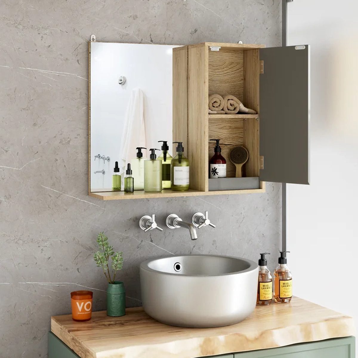 A wooden cabinet with toiletries is open above a round sink. Gray walls and a mirror accentuate the modern bathroom setup.