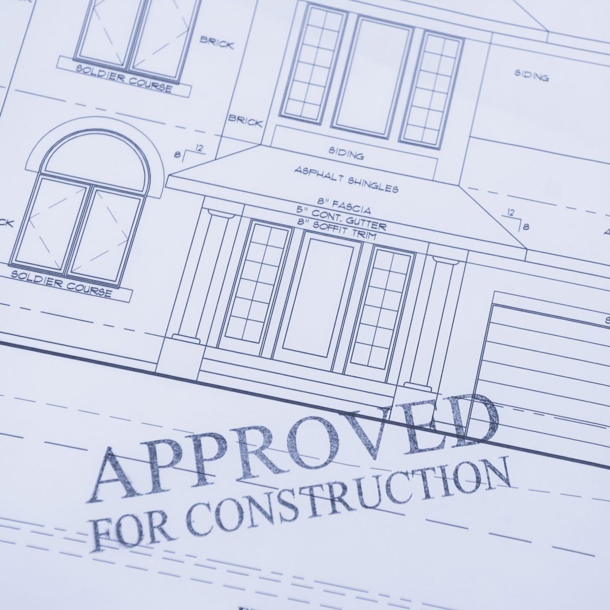 Blueprints featuring detailed drawings of a house outline, marked “APPROVED FOR CONSTRUCTION,” indicating approval for building within a spe