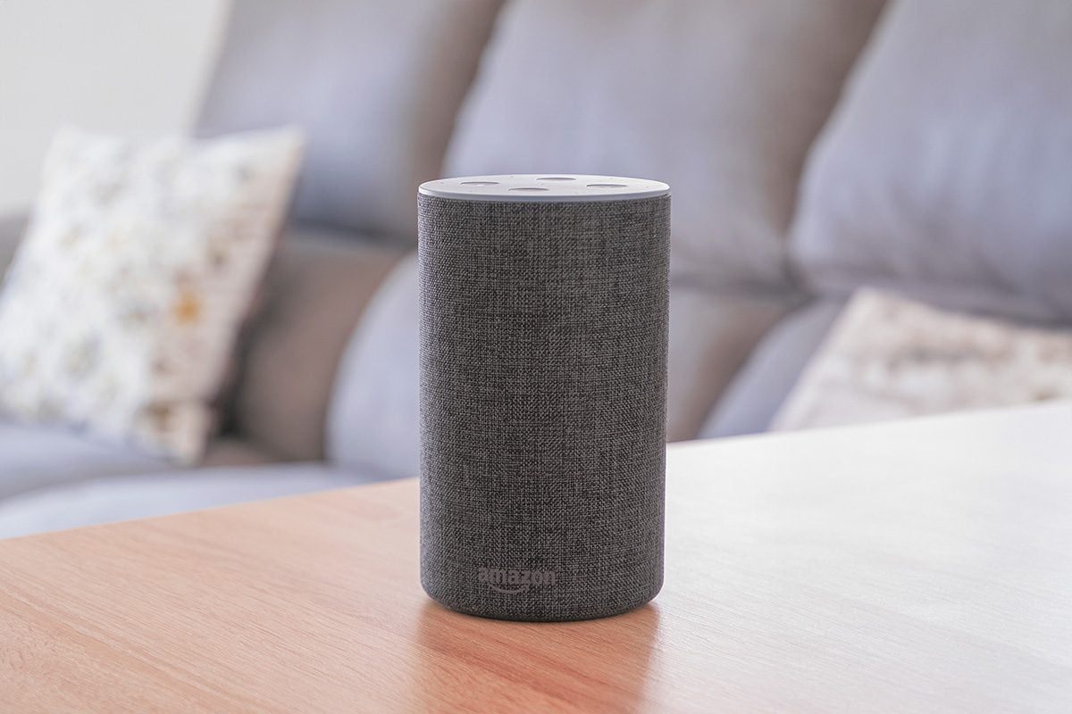 Dark grey Amazon Alexa Echo in a living room on a wooden table