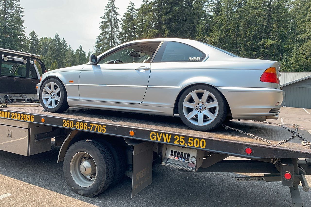 Silver BMW on a tow truck