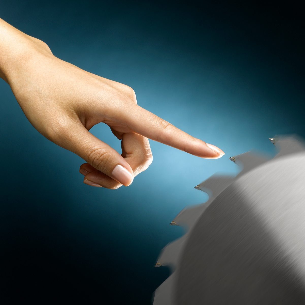 A hand is reaching out to touch a spinning circular saw blade against a soft blue background, suggesting a moment of tension or danger.