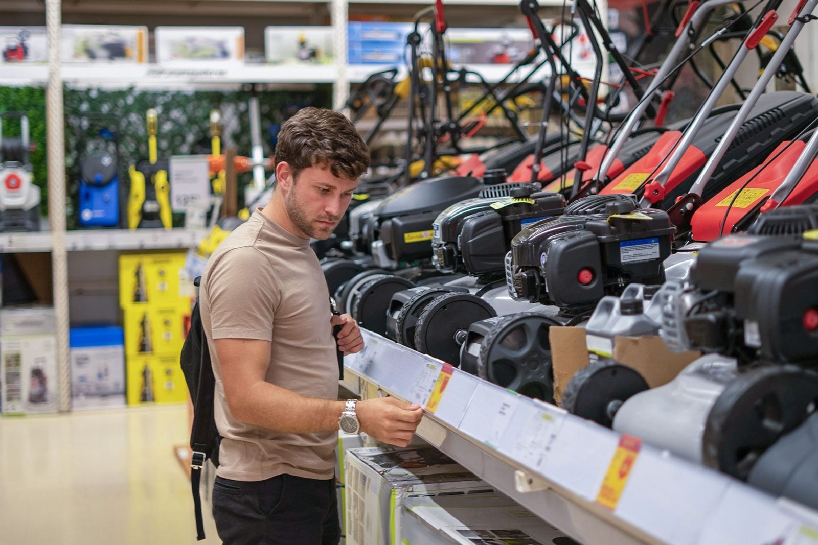 Electric Vs. Gas Lawn Mowers, Customer examining product