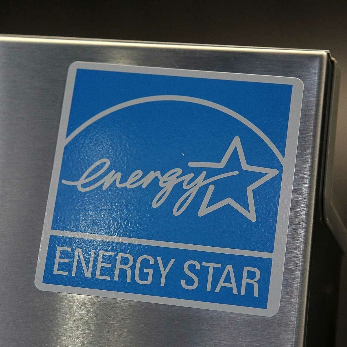 A blue and white label displays the "Energy Star" logo, indicating energy efficiency, affixed to a metallic surface, likely a kitchen applia