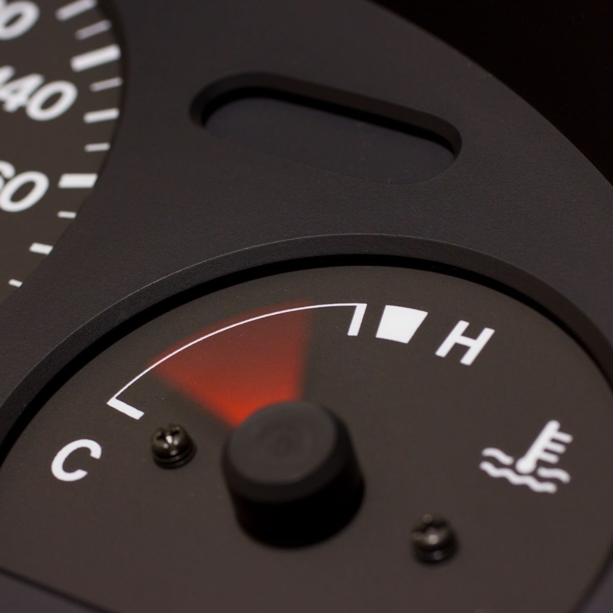 A temperature gauge shows a reading near the high mark. It is embedded in a dark, flat panel with numeric indicators surrounding it.