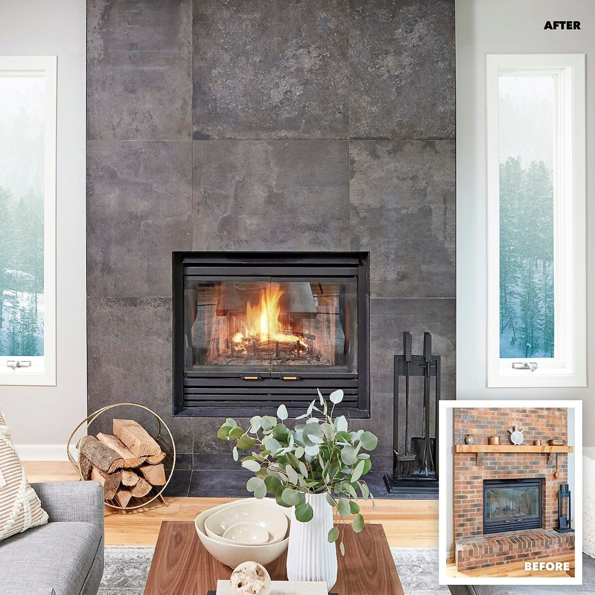 A modern fireplace with a lit fire sits against a dark stone wall, surrounded by a cozy living room featuring plants and natural light from
