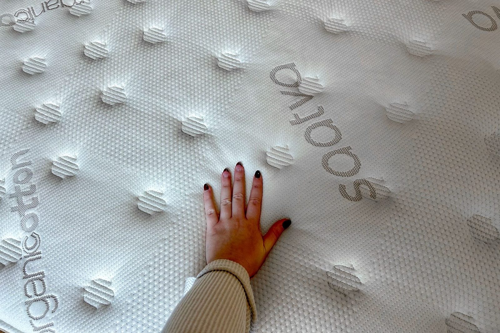 Woman's hand on mattress