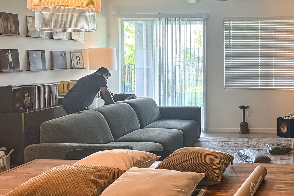delivery team member setting up Povison Aurora Power Sleeper Sofa in the living room