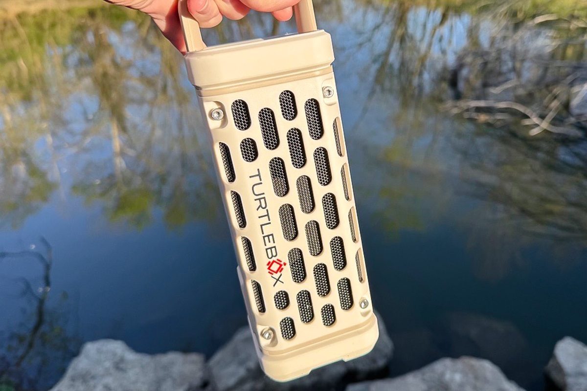 Turtlebox Ranger being held in front of a body of water
