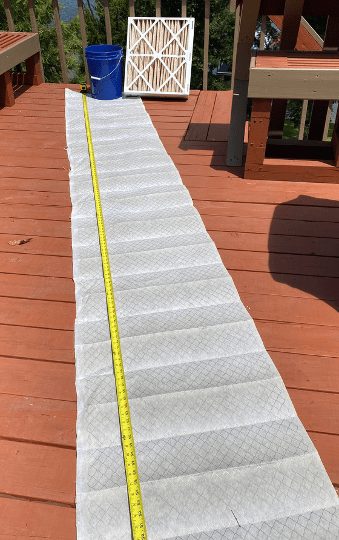 The filter media of a 21 x 23.5 x 5-inch pleated filter stretched out to its full length.