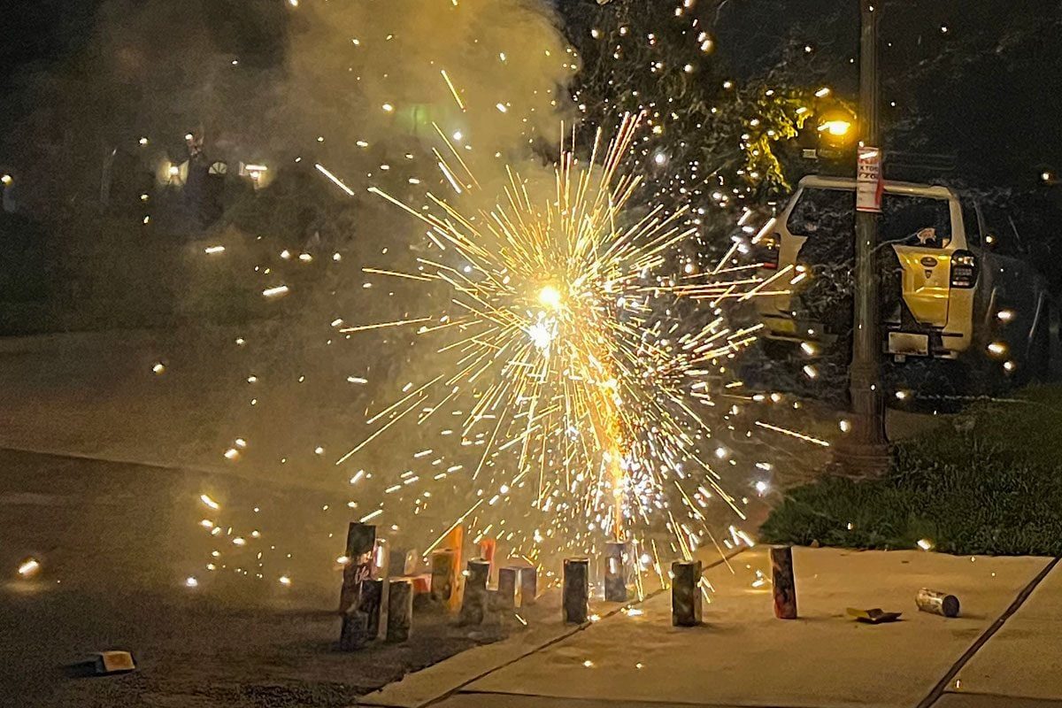 Playful and whimsical view of fireworks on a dark summer night. Celebrating Fourth of July and playing with fireworks.
