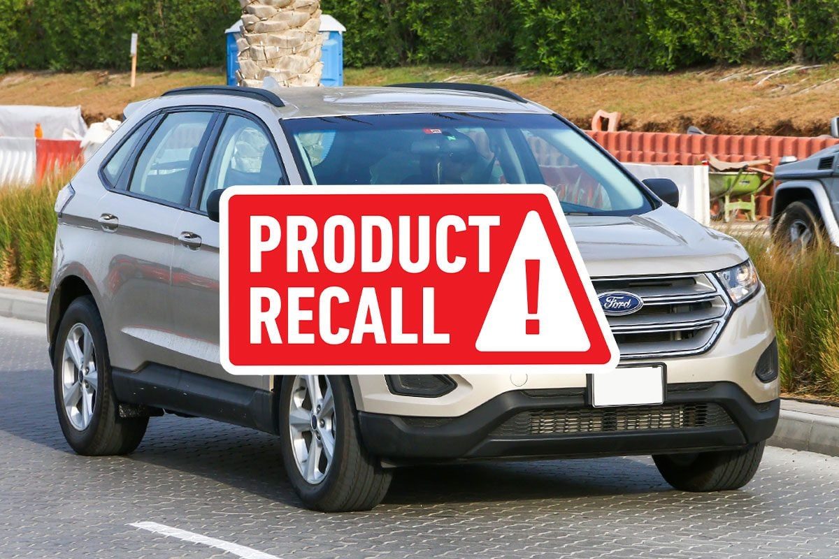 Crossover car Ford Edge in the city street with recall graphics