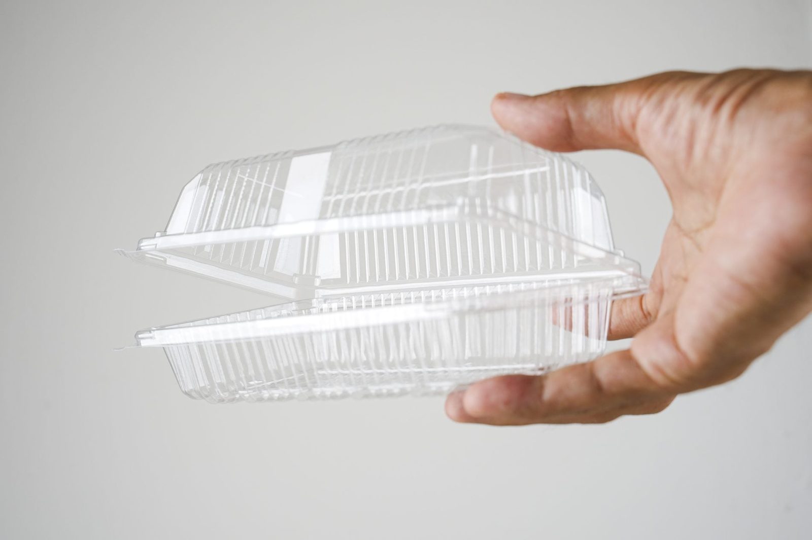 hand holding plastic take out container