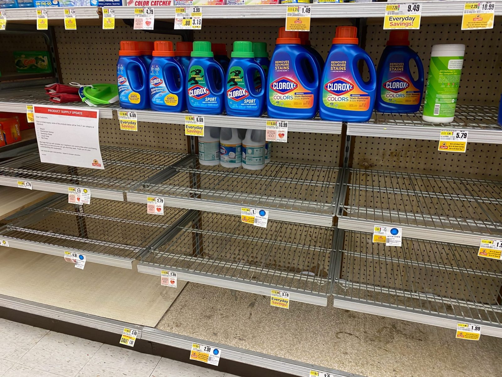 A shelf displays various laundry detergents, some bottles filled, while lower sections are mostly empty, indicating low stock in a grocery s