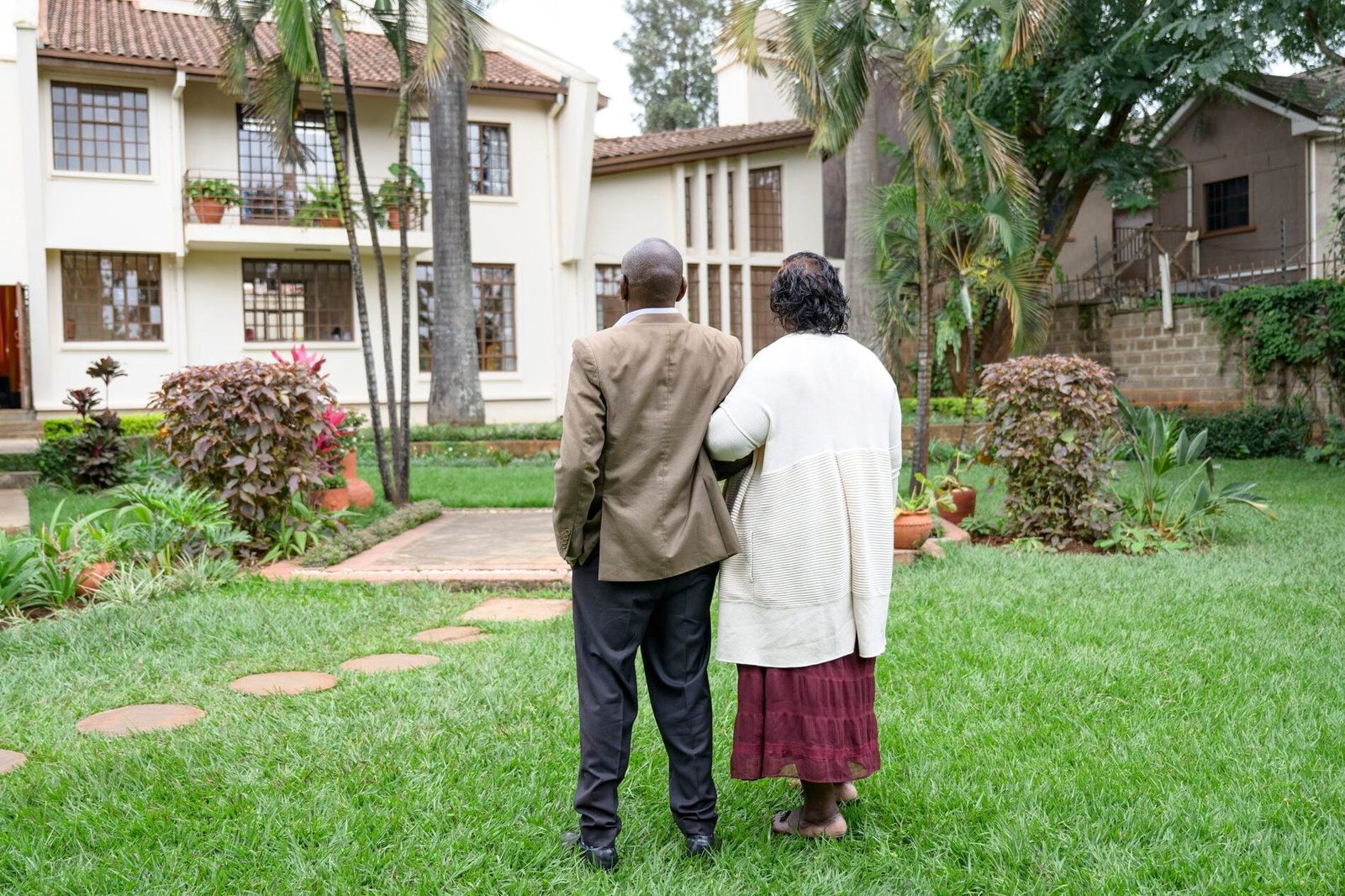 Outdoor portrait of African couple admiring their home