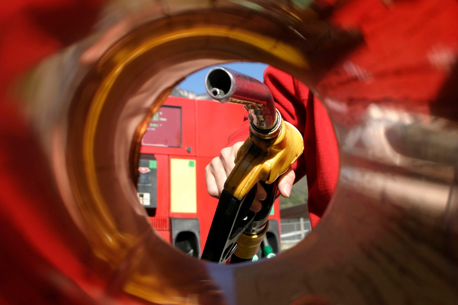 View from inside a car's gas tank intake with a gas pump entering it