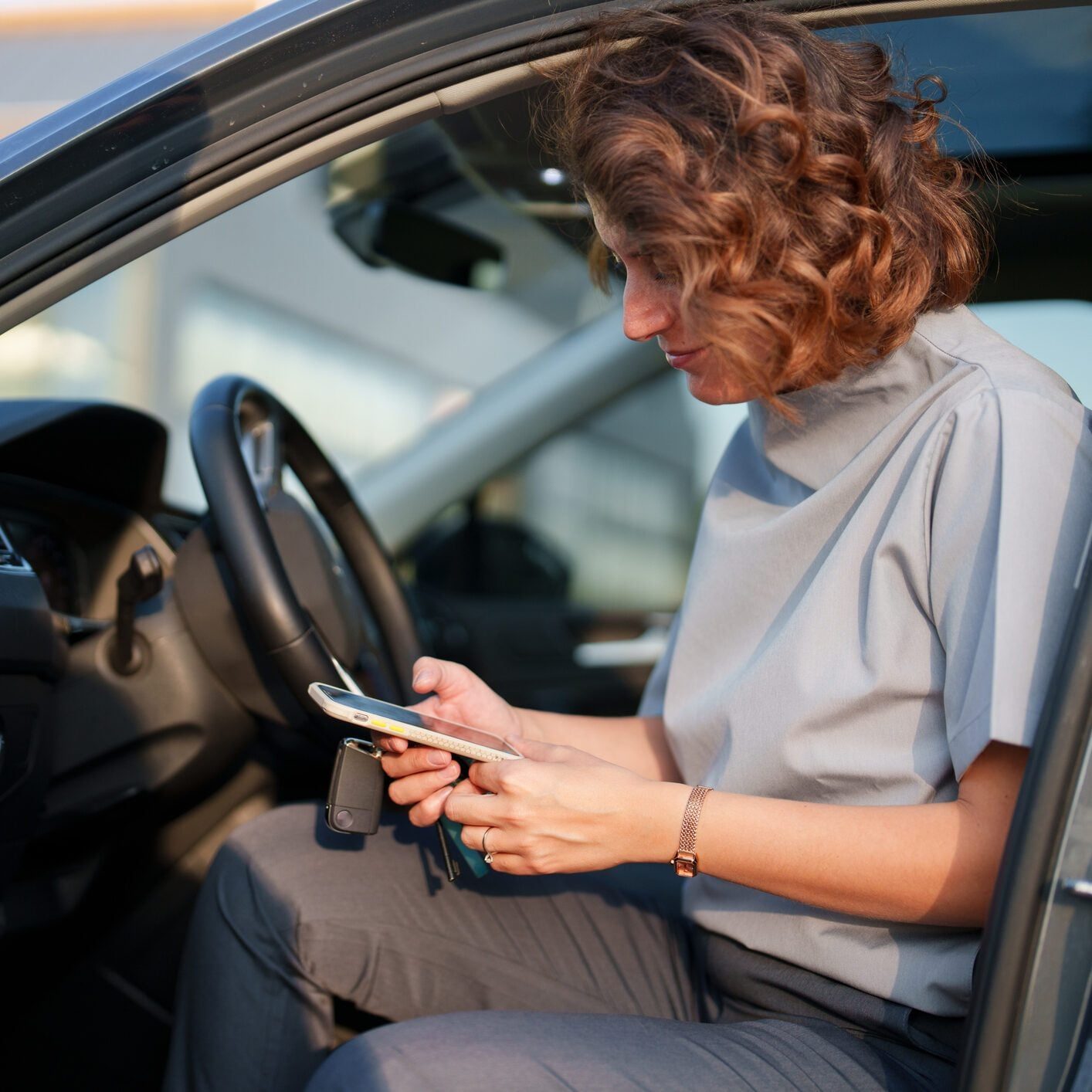 Woman using mobile phone in her car