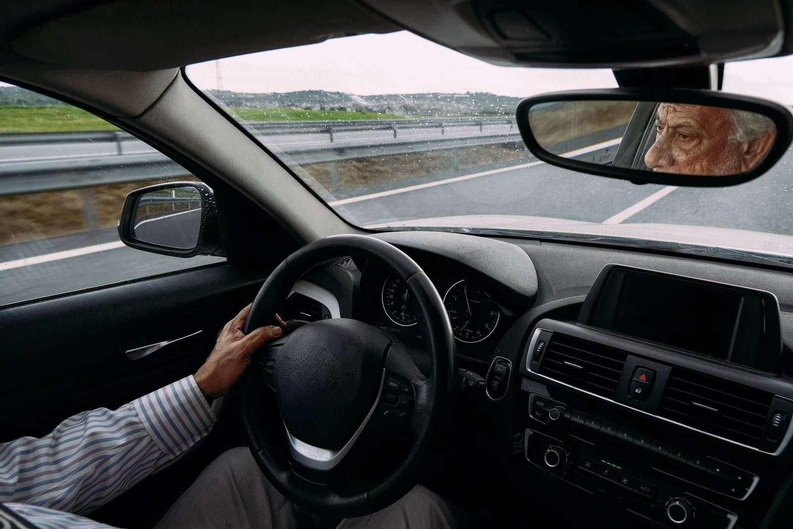 Senior businessman driving a car on a rainy day