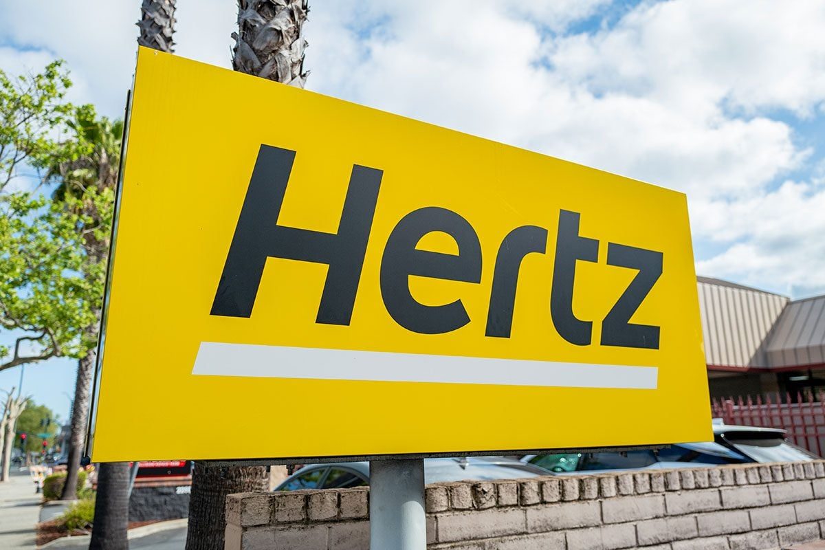Close-up of sign with logo for Hertz rental car agency,