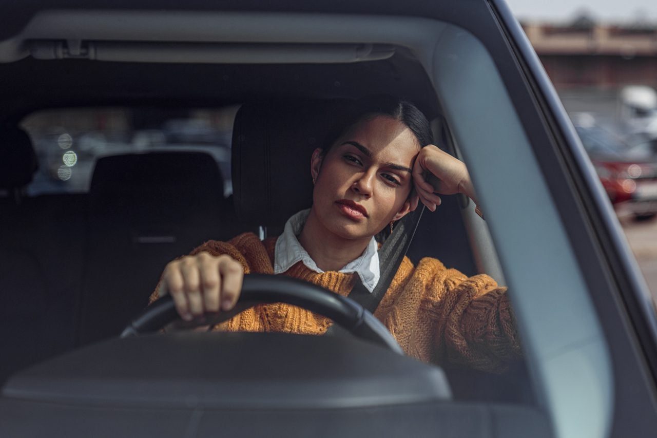 woman driving a car and waiting in traffic