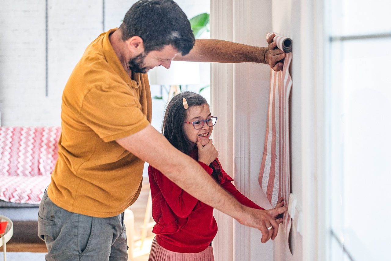 Father and daughter choosing new wallpapers for their home