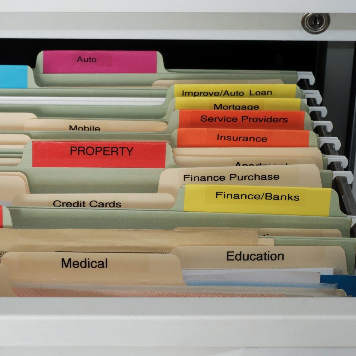 A filing cabinet drawer displays organized folders labeled with categories like "Auto," "Property," and "Medical," in a structured office en