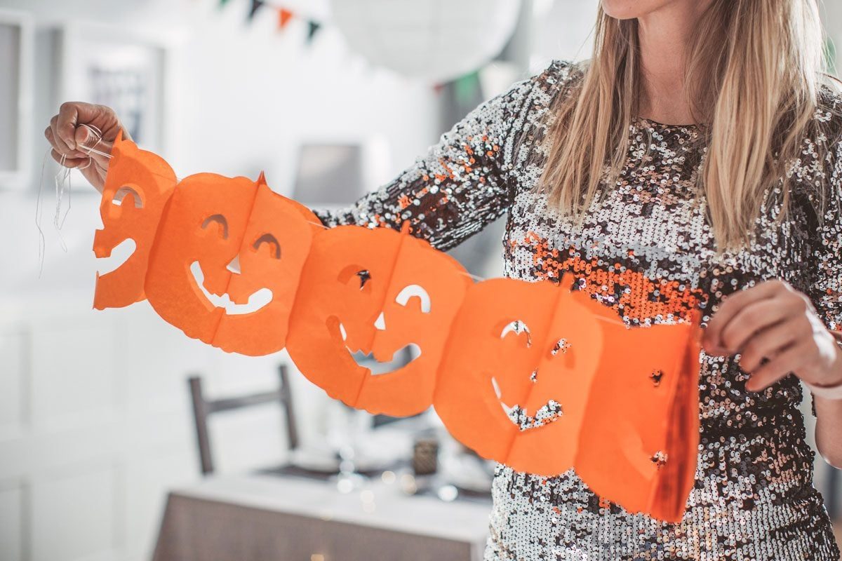 woman putting up fall decorations
