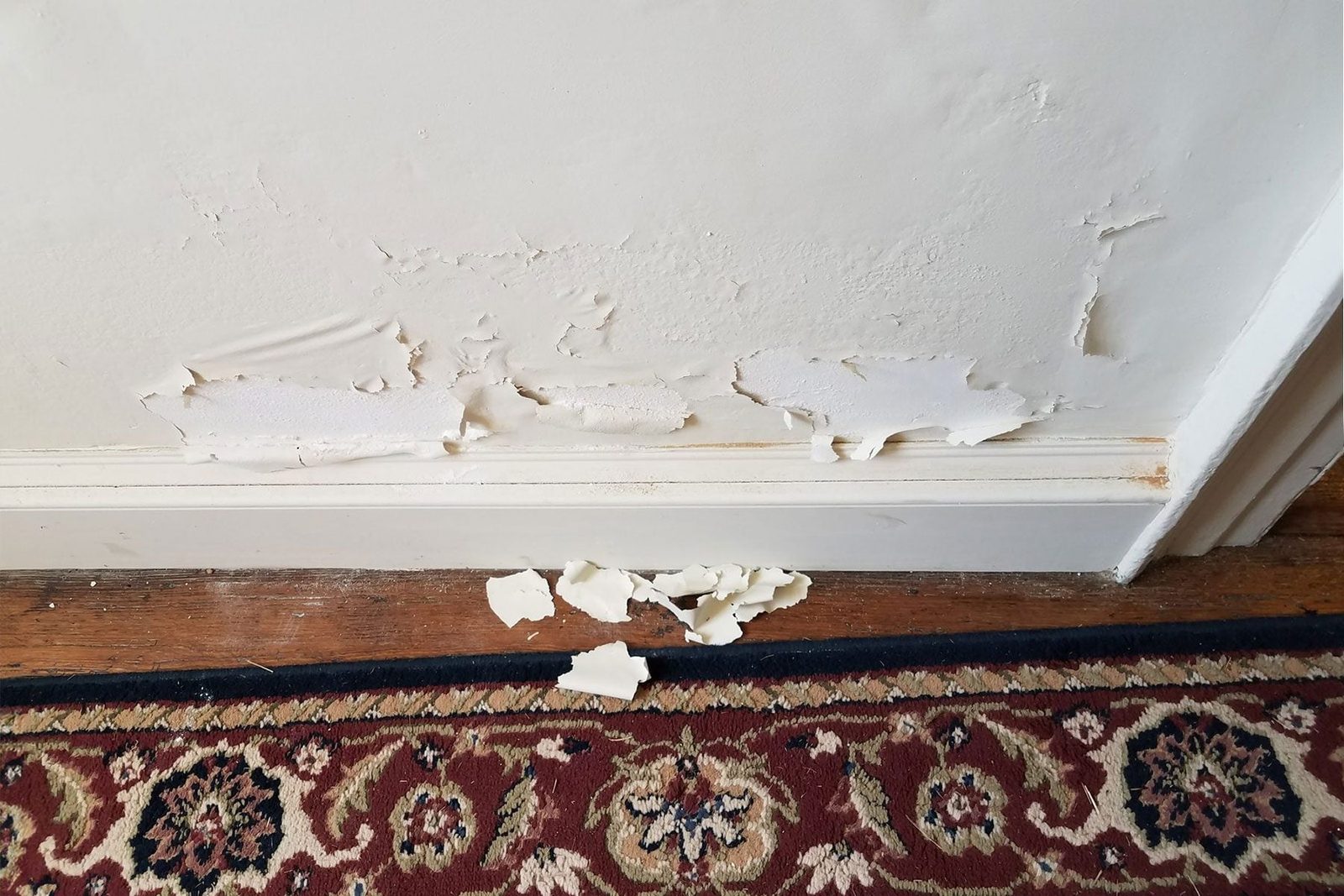 white paint flaking or chipping off of wall