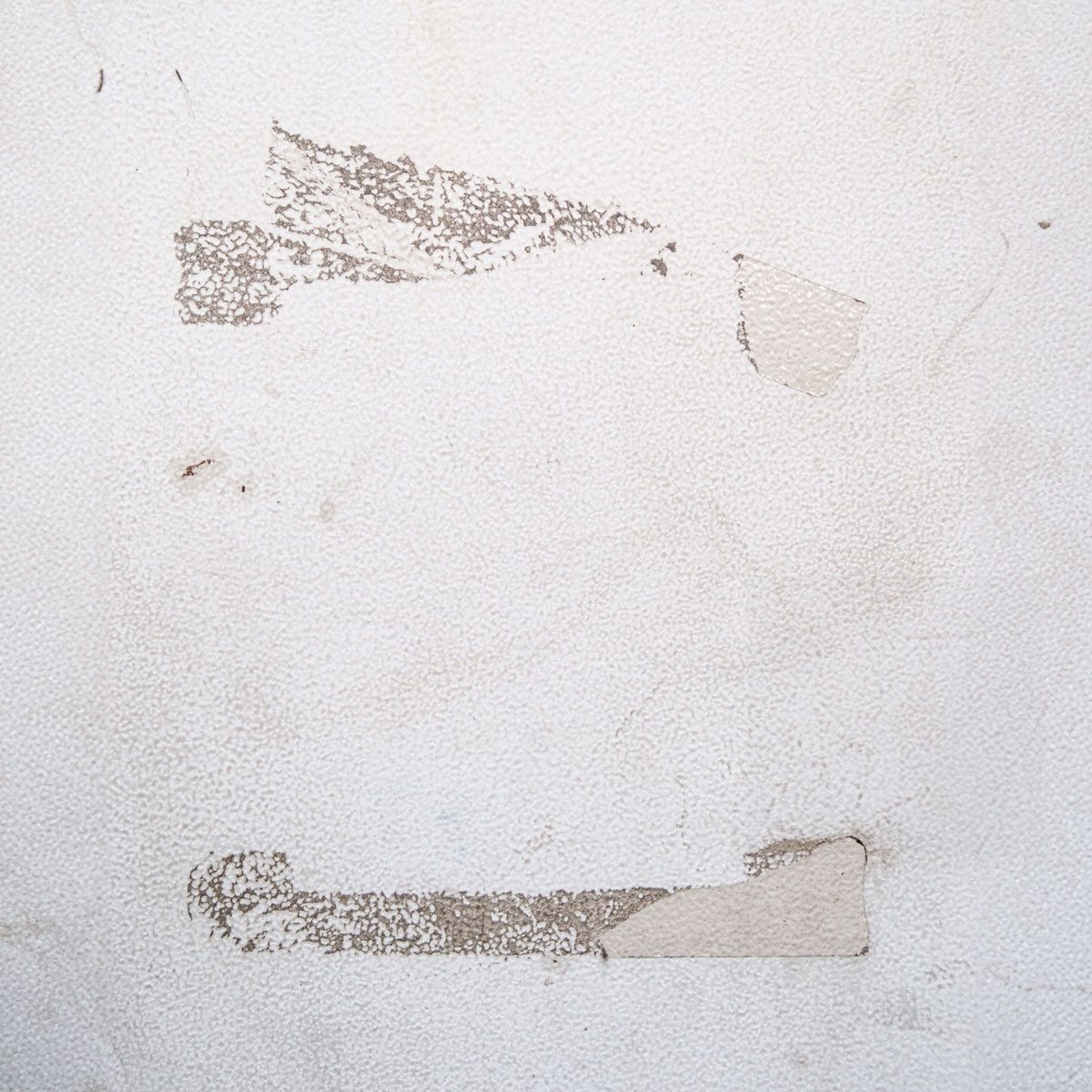 Dirty old white wall with tape marks and grime