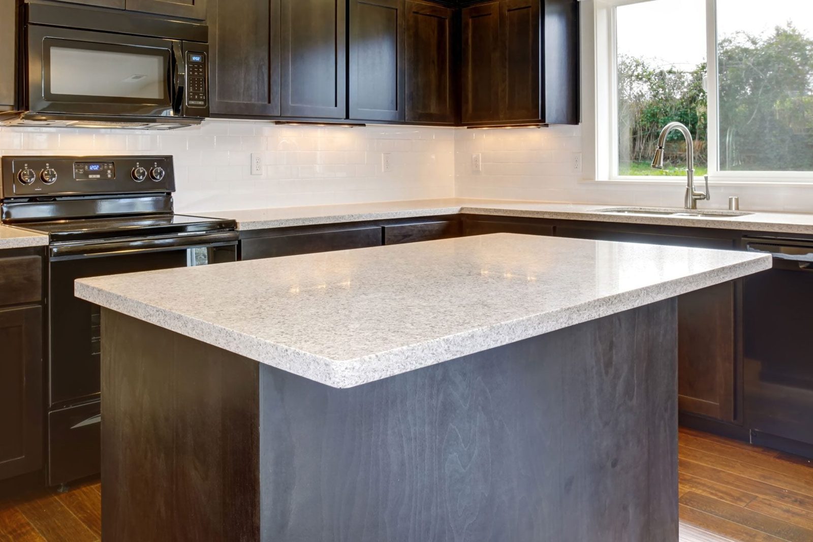 Modern kitchen with stained cabinets, and island.