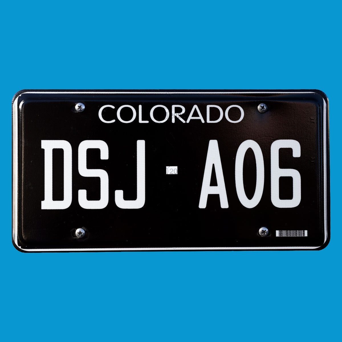 Black License plate on blue colored background