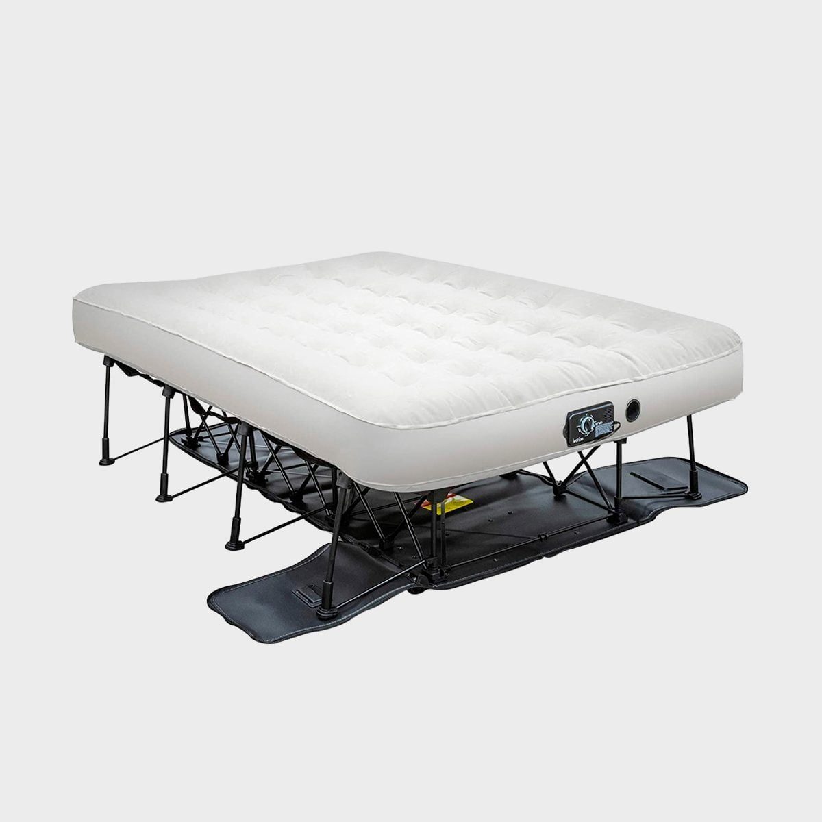 An elevated air mattress is set up on a black frame, designed for sleeping. The background is plain and light-colored.