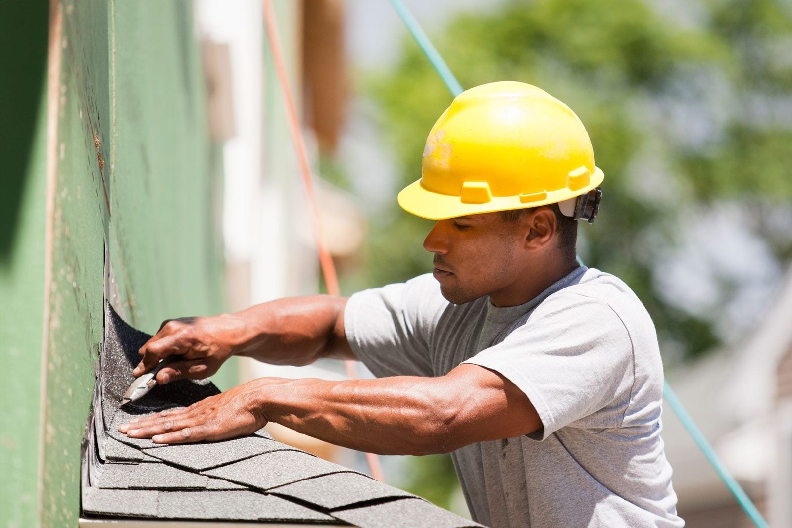 Carpenter trimming shingles for the roofing