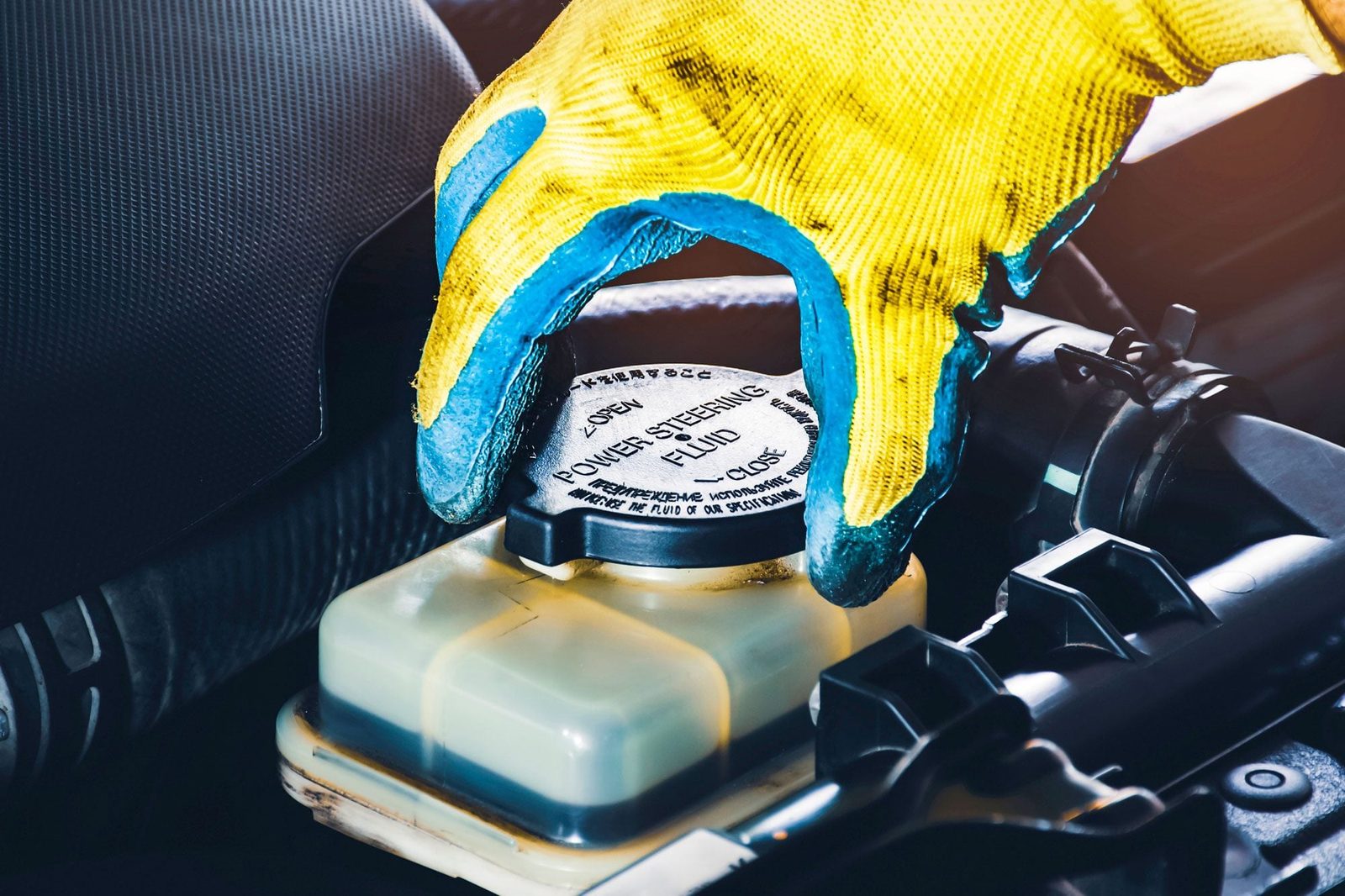 Mechanics Hand Opens Up The Power Steering Fluid Cap