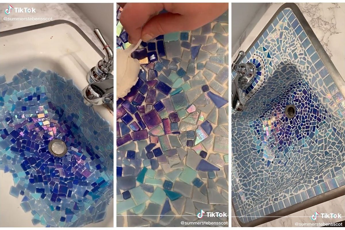 A sink displays a mosaic of blue and purple tiles. A hand applies white material to fill gaps, enhancing the decorative surface.