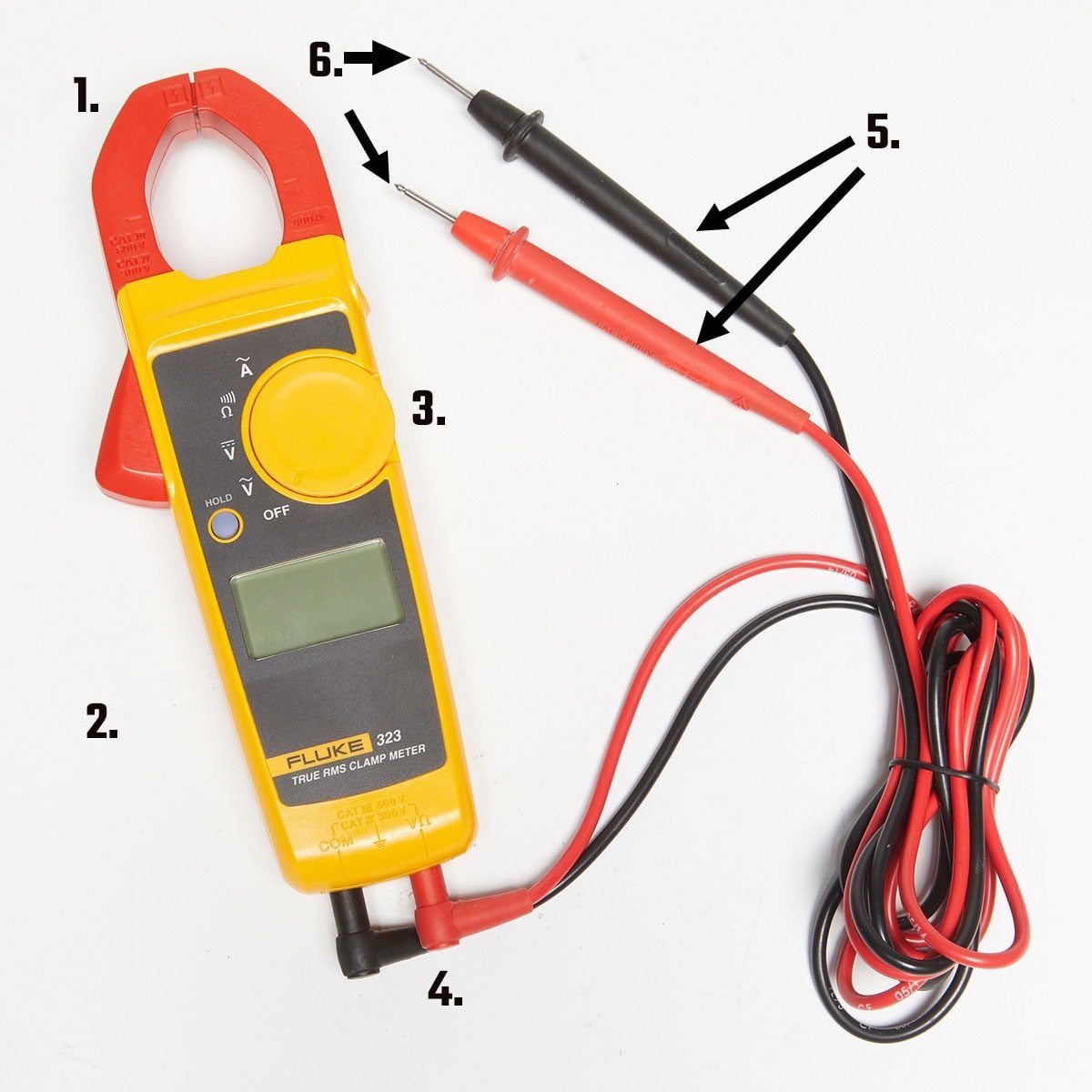 A digital clamp multimeter displays readings, with a red and black lead attached, resting on a plain surface while measuring electrical current from a circuit.