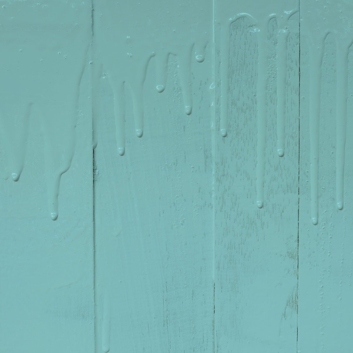 A textured wooden surface, covered in light blue paint, is dripping downwards, creating a glossy effect against the pale backdrop.
