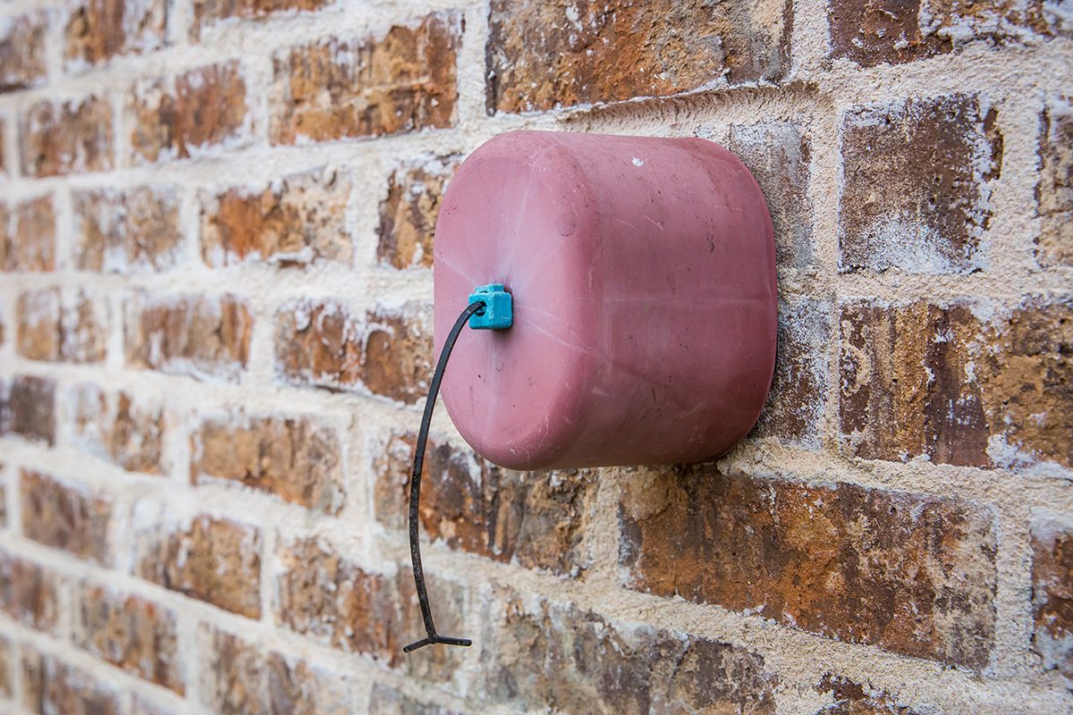Faucet cover on exterior brick wall