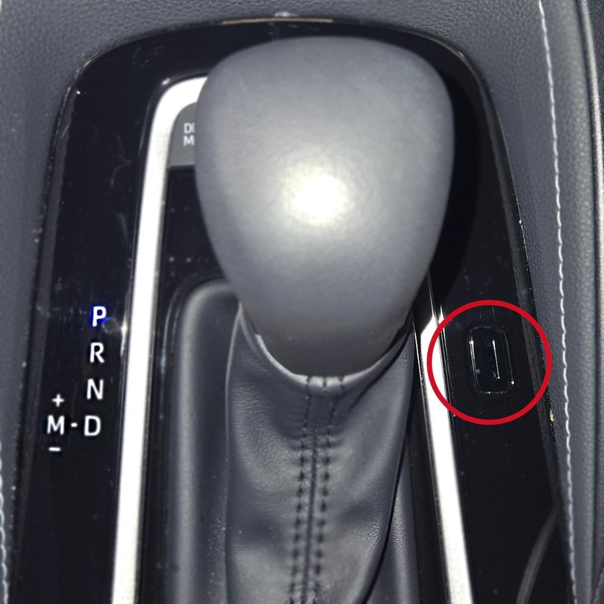 Car gear shift with a small slot to the right of the handle, circled in red