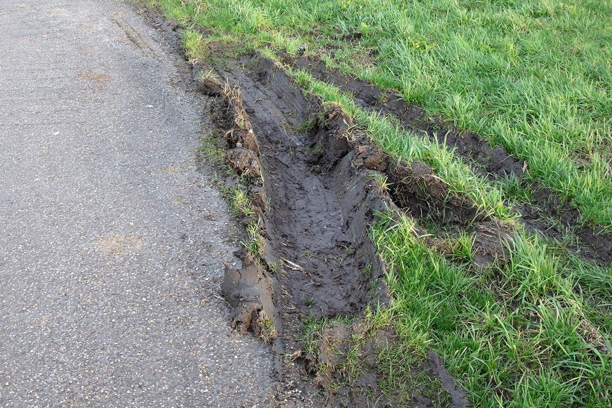 Closeup view of car wheel tracks traces in mud next to road