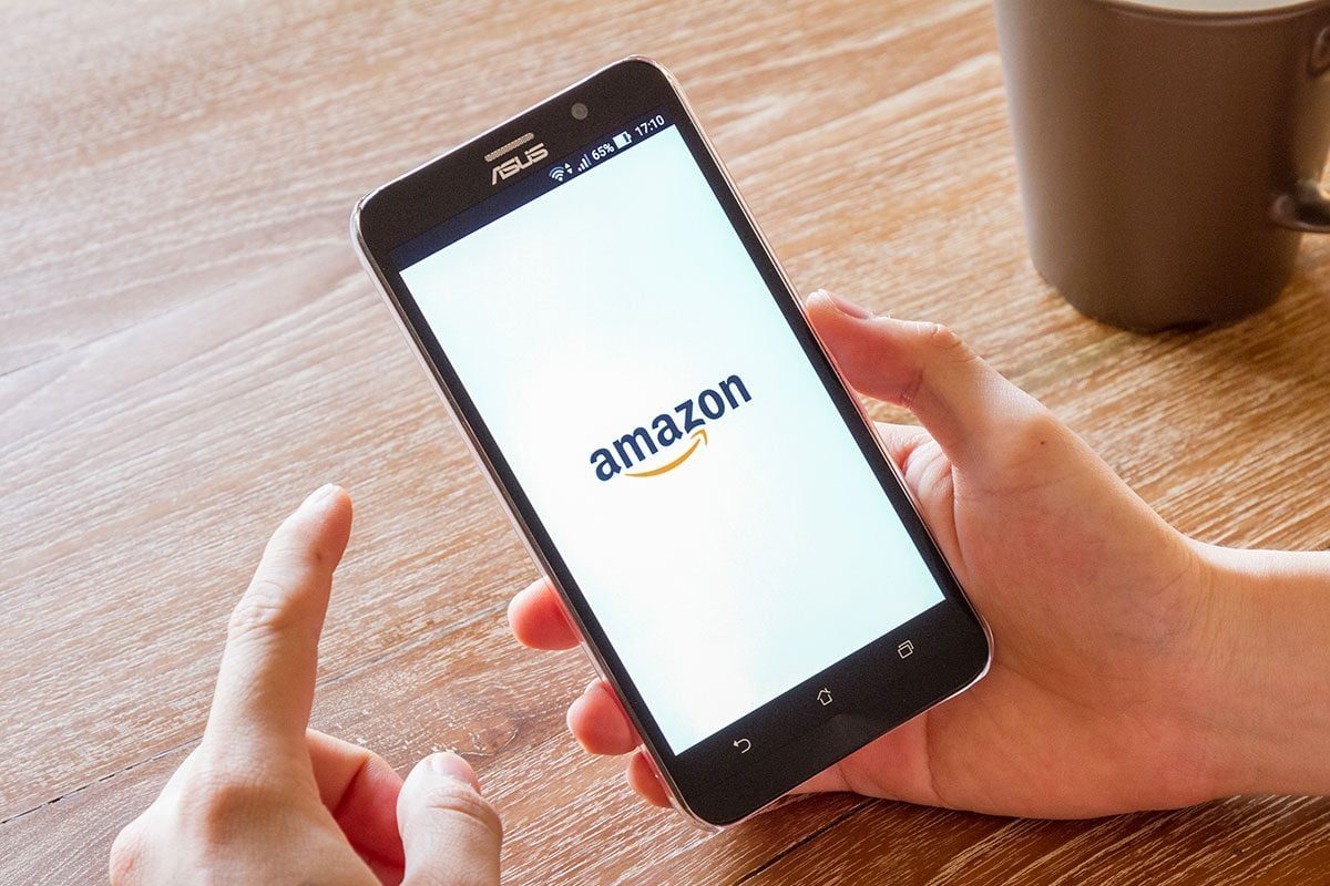 man hand holding screen shot of Amazon application