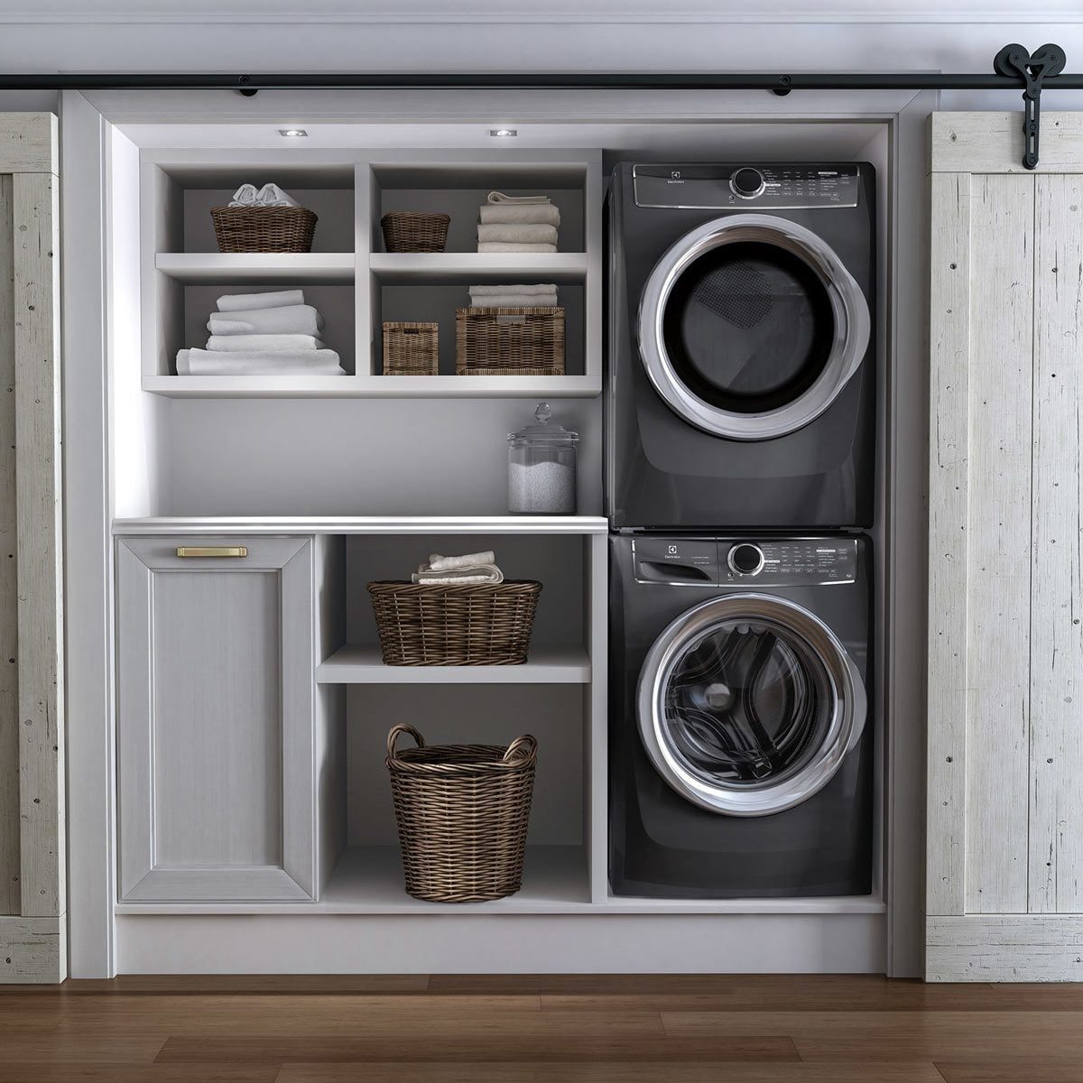 A stacked washer and dryer occupy a stylish laundry nook, surrounded by neatly organized shelves with baskets and neatly folded towels.