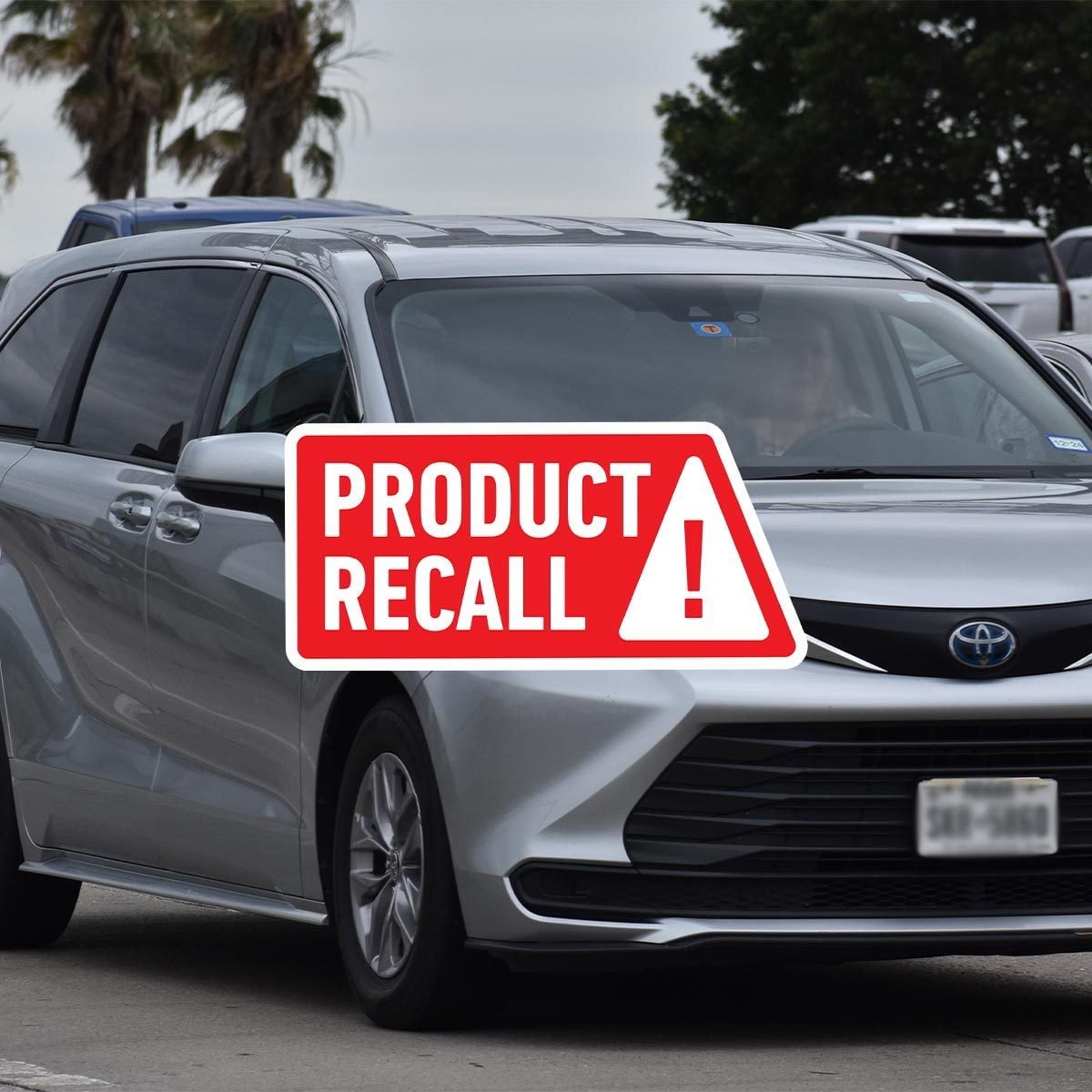 Gray Toyota Sienna with a red "product recall" sticker on top
