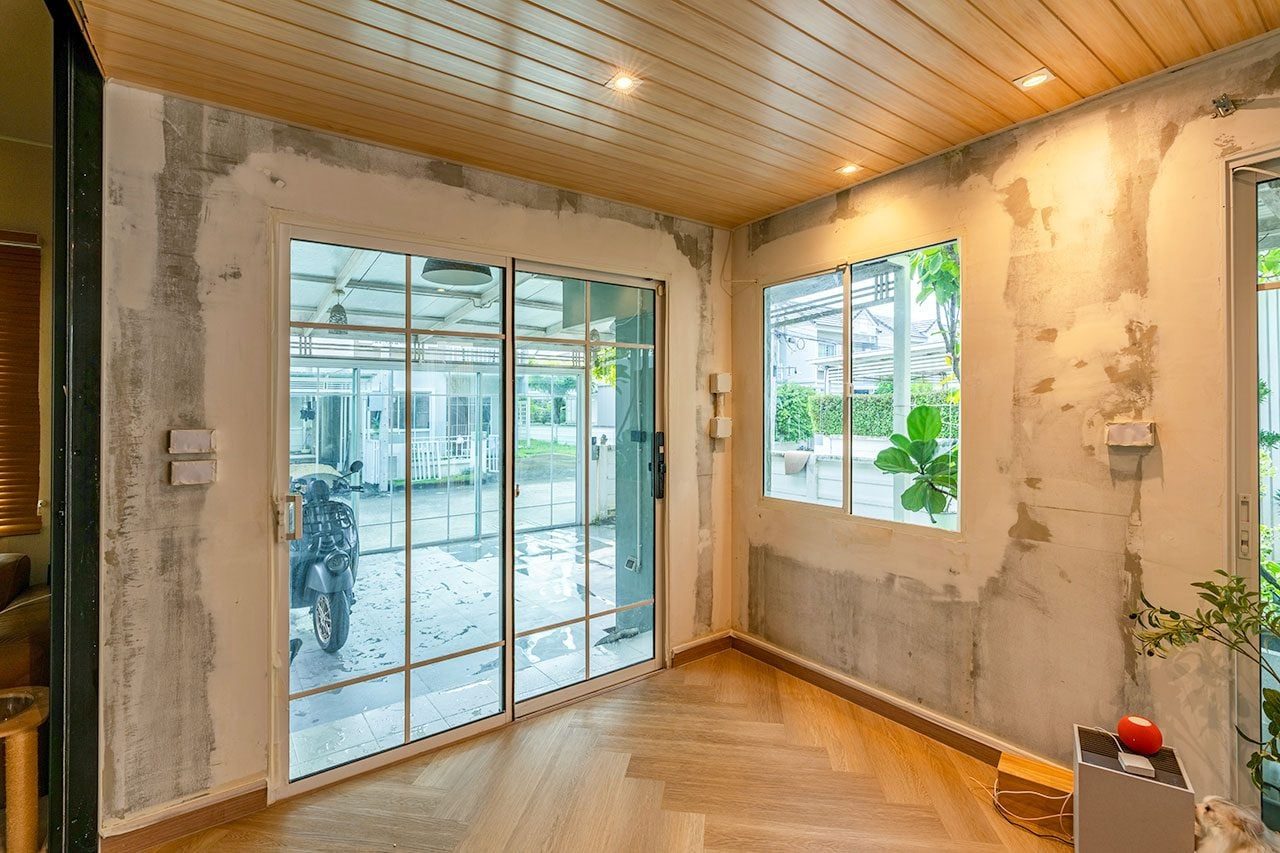 Unfinished room with raw concrete walls and wooden ceiling