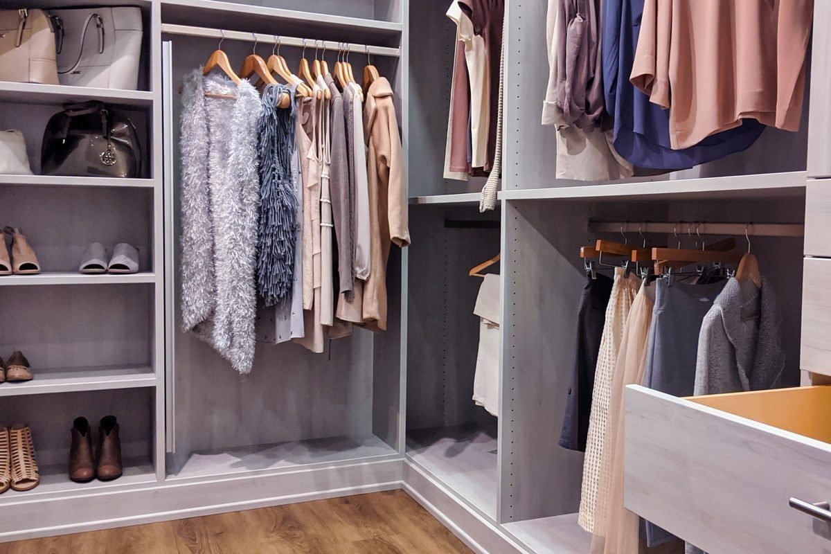 A well stocked walk in closet with all clothing and shoes organized within