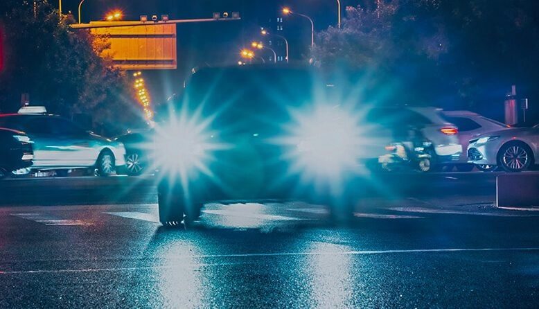 Illuminated Headlights On Street At Night