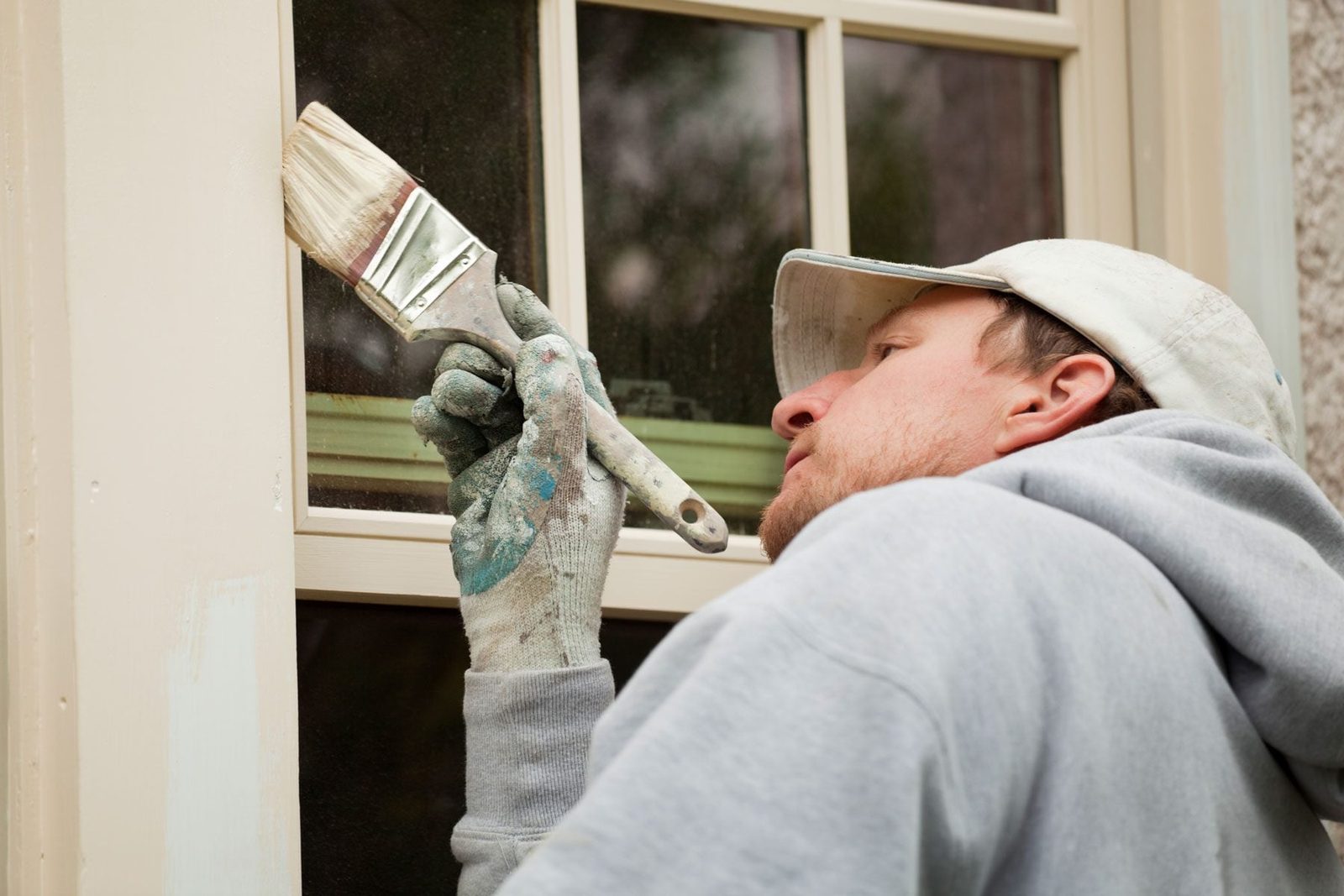 House Painter Working on Exterior Home Maintenance Improvement Painting Work