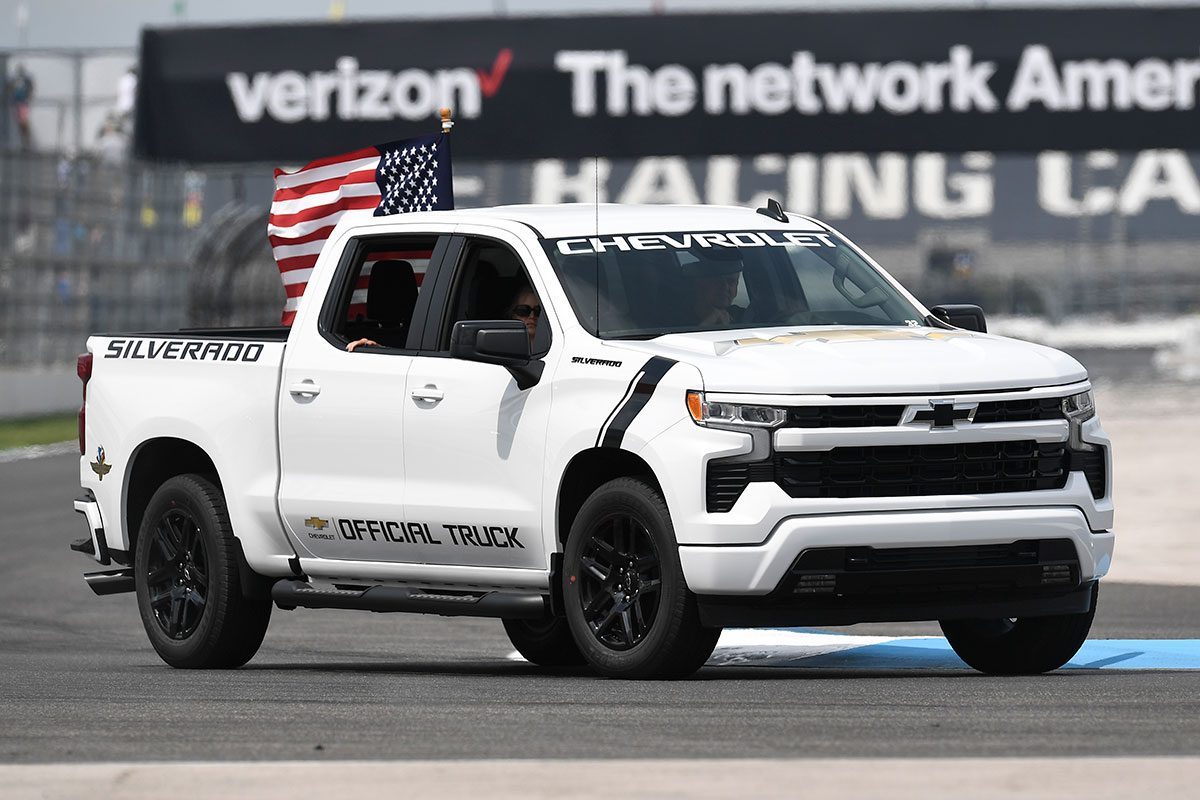 A Chevrolet Silverado pace truck drives through turn seven on a parade lap