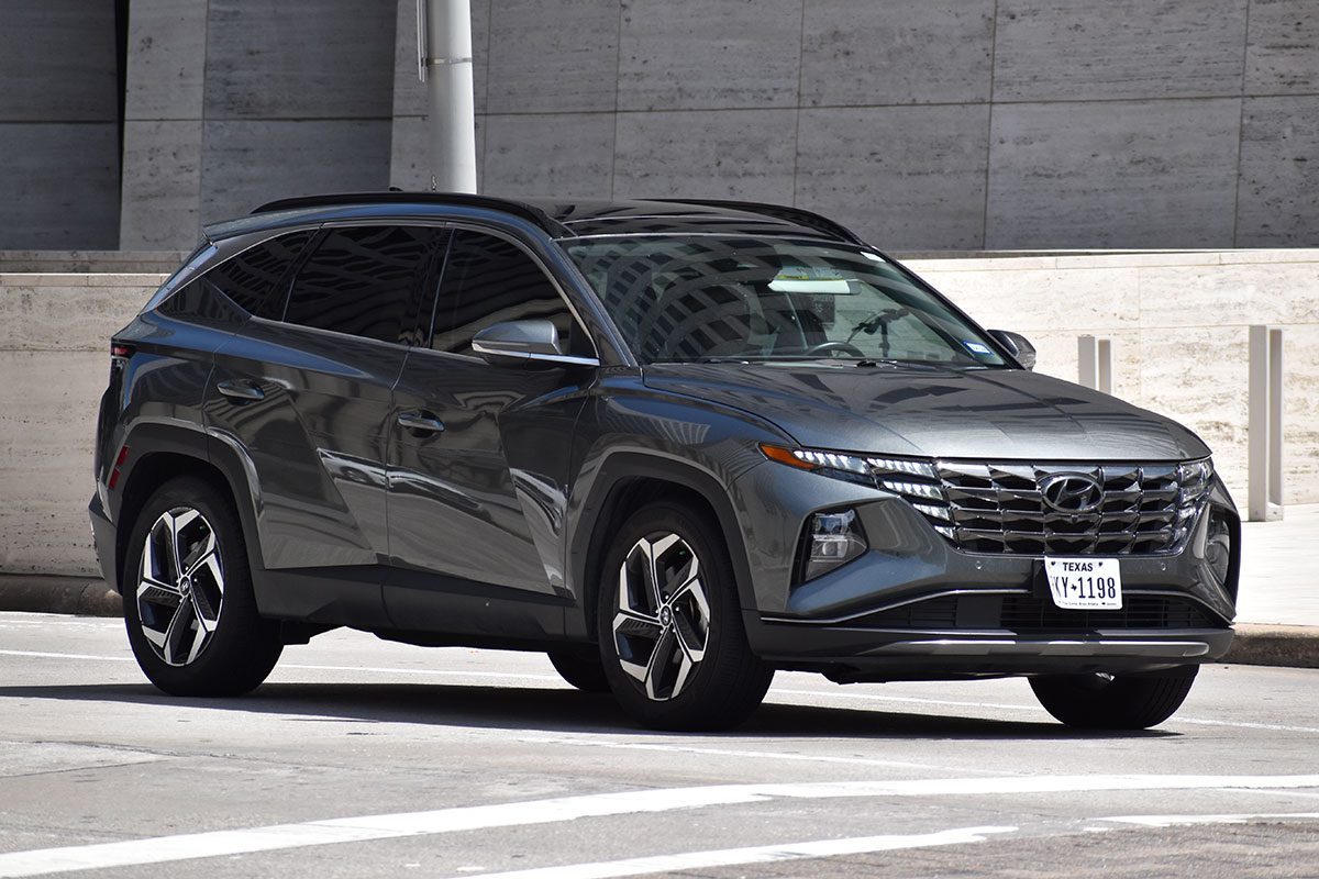 A gray Hyundai Tucson SUV traveling near an office building