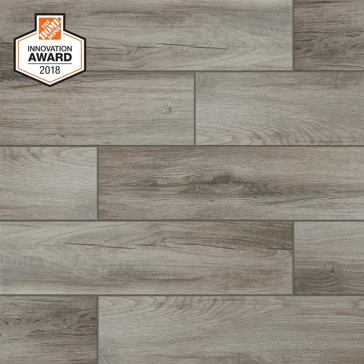 Gray wood-like flooring tiles are arranged in a staggered pattern for a natural appearance, with a badge indicating an innovation award in t